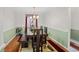 Bright dining room with wood floors, a large table, an ornate chandelier, and wainscoting at 1113 Lyric Dr, Deltona, FL 32738