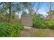 Outdoor storage shed nestled among trees and greenery in the backyard at 1113 Lyric Dr, Deltona, FL 32738