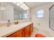 Bathroom featuring a single sink vanity, wood cabinets, modern fixtures, and a tiled shower and flooring at 11604 Acosta Ave, Orlando, FL 32836