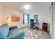 Cozy bedroom with plush blue couch, desk with dual monitors, and soft, colorful rug enhancing the space at 11604 Acosta Ave, Orlando, FL 32836