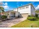 Charming two-story home with a covered porch, well-manicured lawn, and a brick-paved driveway at 11604 Acosta Ave, Orlando, FL 32836