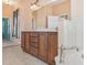 Bathroom featuring a double vanity with dark wood cabinets, tile floors, and a soaking tub at 12018 Se 175Th Loop, Summerfield, FL 34491