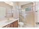 Bathroom with a shower, wood cabinet sink, a toilet and marble countertop at 12018 Se 175Th Loop, Summerfield, FL 34491