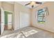 Bright, carpeted bedroom featuring a ceiling fan, natural light, and a closet at 12018 Se 175Th Loop, Summerfield, FL 34491