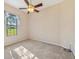 Carpeted bedroom featuring a ceiling fan, natural light, and a spacious window view at 12018 Se 175Th Loop, Summerfield, FL 34491