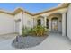 Home entrance featuring a welcoming front door, beautiful columns, and well-maintained landscaping at 12018 Se 175Th Loop, Summerfield, FL 34491