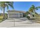 Charming home featuring a three-car garage and mature landscaping under clear blue skies at 12018 Se 175Th Loop, Summerfield, FL 34491