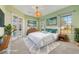 Staged bedroom with decor, large windows, light green walls and access to the patio at 12018 Se 175Th Loop, Summerfield, FL 34491