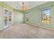 Bedroom with light green walls, carpet flooring, three windows and access to an outside patio at 12018 Se 175Th Loop, Summerfield, FL 34491