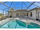 Enclosed pool area featuring a screened-in structure, access doors and an additional patio space at 12018 Se 175Th Loop, Summerfield, FL 34491