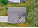 An aerial view of a home showcasing the layout, roof, patio, and surrounding greenery at 1226 E Schwartz E Blvd, Lady Lake, FL 32159