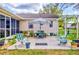 Outdoor patio with seating, including a table with a striped umbrella and pergola with hanging plants at 1226 E Schwartz E Blvd, Lady Lake, FL 32159