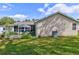 Side view of a home's exterior, featuring a grassy lawn, patio area with pergola, and neutral-toned siding at 1226 E Schwartz E Blvd, Lady Lake, FL 32159