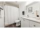 Bright bathroom with a white shower curtain, decorative mirror, and granite countertop vanity at 128 Calabria Springs Cv, Sanford, FL 32771