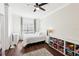 Bright bedroom featuring wood floors, fan, and natural light at 128 Calabria Springs Cv, Sanford, FL 32771