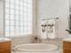 Soaking tub in the main bathroom featuring a glass block window at 13336 Lake Turnberry Cir, Orlando, FL 32828