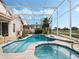 Screened-in pool and spa with tile accents, surrounded by lush landscaping and a serene outdoor view at 13336 Lake Turnberry Cir, Orlando, FL 32828