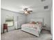 Bright bedroom features neutral carpet, white furniture, a ceiling fan, and large window at 1385 Evergreen Park Cir, Lakeland, FL 33813