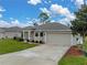 Inviting home featuring a manicured lawn, two-car garage, and a welcoming entrance at 1385 Evergreen Park Cir, Lakeland, FL 33813