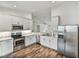 Modern kitchen with white cabinets, stainless steel appliances, and wood-look floors at 1385 Evergreen Park Cir, Lakeland, FL 33813