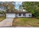 Charming single-story home with a well-manicured lawn and attached garage with a concrete driveway at 142 Habersham Dr, Longwood, FL 32779