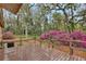 Backyard view featuring a wood deck and pink azalea bushes surrounded by mature trees at 14226 Nell Dr, Orlando, FL 32832