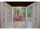 View from inside French doors to deck with pink azalea bushes at 14226 Nell Dr, Orlando, FL 32832