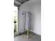 Garage interior showcasing the water heater, epoxy flooring, and access to the side yard at 14434 Swanley St, Orlando, FL 32832