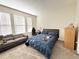 Cozy bedroom with a comfortable bed, a gray sofa, and natural light from the windows at 15127 Book Club Rd, Winter Garden, FL 34787