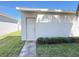 Home exterior showing a side entrance with a white door and landscaping at 15127 Book Club Rd, Winter Garden, FL 34787