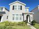 Charming two-story home with gray stucco exterior, stone archway, and manicured front lawn at 15127 Book Club Rd, Winter Garden, FL 34787