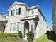 Charming two-story home with gray stucco exterior, stone archway, and manicured front lawn at 15127 Book Club Rd, Winter Garden, FL 34787