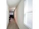 Bright hallway with wood-look tile flooring leading to a living area with large windows at 15127 Book Club Rd, Winter Garden, FL 34787