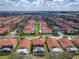 Overhead view of a neighborhood with tile-roofed homes, green lawns, and screened-in pools at 1520 Solana Cir, Davenport, FL 33897