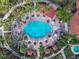 An aerial shot of the pool with cabanas and palm trees in a landscaped community center provides a vibrant oasis at 1520 Solana Cir, Davenport, FL 33897