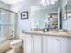 Bathroom featuring double sinks with white cabinets, framed mirrors, and a glass-enclosed shower at 1520 Solana Cir, Davenport, FL 33897