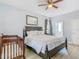 Comfortable bedroom featuring dark wood furniture, ceiling fan, crib, and ensuite bathroom at 1520 Solana Cir, Davenport, FL 33897