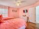 Pink bedroom with two beds, a dresser, a mounted TV, and wood-look laminate flooring at 1520 Solana Cir, Davenport, FL 33897