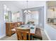 Dining room with rustic wooden table and chairs set for six people, lit by a modern chandelier at 1520 Solana Cir, Davenport, FL 33897