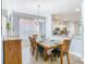 Well-lit dining room with an adjacent kitchen featuring a rustic wooden table set for six guests at 1520 Solana Cir, Davenport, FL 33897