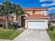 Charming two-story home with a red tile roof, well-manicured lawn, and lush landscaping including palm trees at 1520 Solana Cir, Davenport, FL 33897