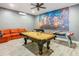 Spacious game room featuring a pool table, foosball table, air hockey, orange couch, and a vivid Marvel Comics mural at 1520 Solana Cir, Davenport, FL 33897