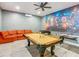 Spacious game room featuring a pool table, foosball table, air hockey, orange couch, and a vivid Marvel Comics mural at 1520 Solana Cir, Davenport, FL 33897