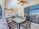 Enclosed outdoor patio with dining table set and ceiling fans adjacent to a view of an outdoor kitchen at 1520 Solana Cir, Davenport, FL 33897