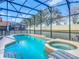 A backyard pool boasts a safety fence and spa, offering a safe and relaxing outdoor retreat at 1520 Solana Cir, Davenport, FL 33897