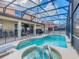 A sparkling pool and spa with a safety fence are set against a backdrop of patio and lush landscaping at 1520 Solana Cir, Davenport, FL 33897