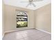 Bright bedroom featuring a ceiling fan, tile floors and a unique arched window at 1716 Terry Ne Cir, Winter Haven, FL 33881