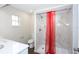 Bathroom showcasing shower, white marble-look tile, vanity, and eye-catching red curtain at 1721 Sandalwood Sw Cir, Winter Haven, FL 33880