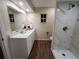 Bathroom featuring white cabinetry, double sinks, a glass-enclosed shower with marble accents at 1721 Sandalwood Sw Cir, Winter Haven, FL 33880