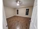 Spacious bedroom featuring wood flooring, neutral wall paint, and a view of windows at 1721 Sandalwood Sw Cir, Winter Haven, FL 33880